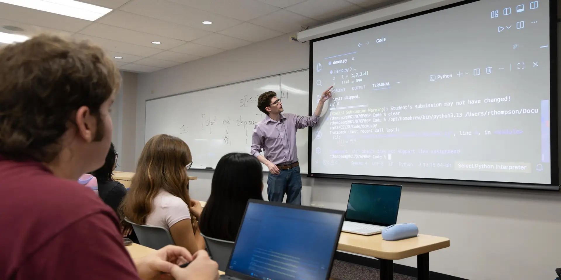 Rob Thompson points to a projected Python coding example while teaching students during a Computer Science for STEM class (CSCI 128) in Berthoud Hall at Colorado School of Mines. Thompson and his colleagues are evolving the undergraduate curriculum to ensure students develop both fundamental programming skills and the technical AI literacy required for the modern tech industry.